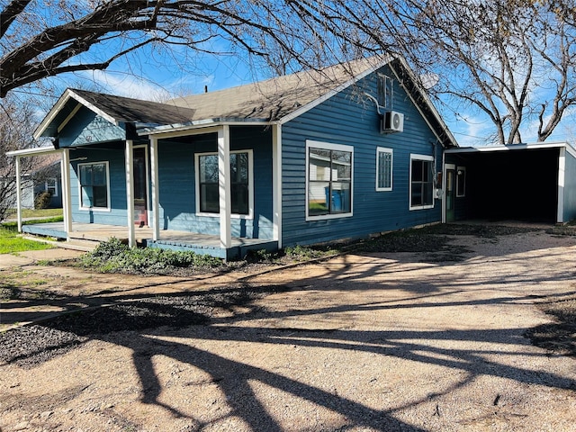 exterior space featuring a porch, a wall mounted air conditioner, and a carport