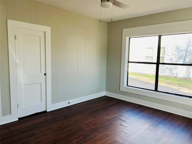 unfurnished room with dark hardwood / wood-style floors and ceiling fan