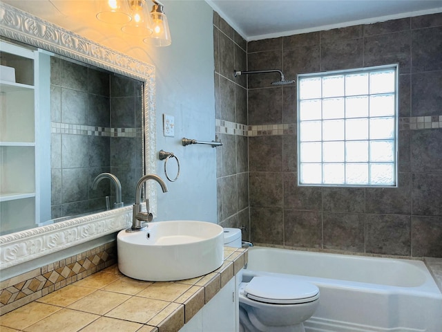 full bathroom featuring tile patterned floors, toilet, tiled shower / bath combo, and sink