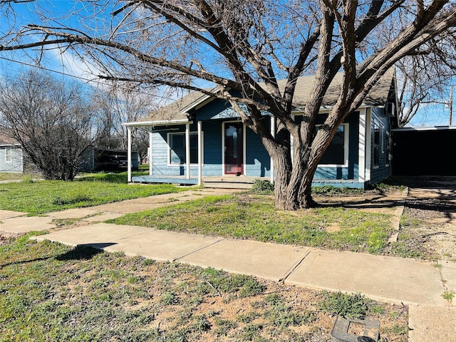 view of front of house with covered porch and a front lawn