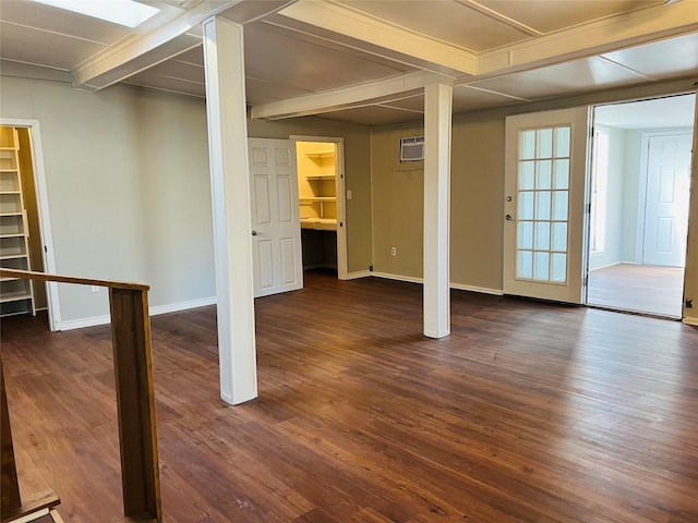 basement with a wall unit AC and dark hardwood / wood-style flooring