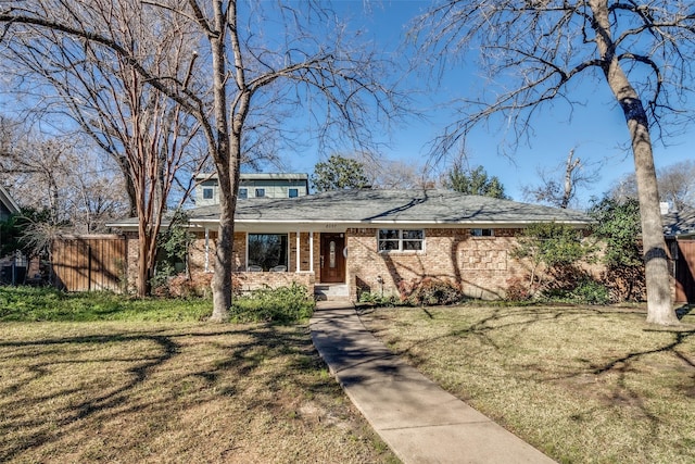 view of front of house featuring a front yard, brick siding, and fence