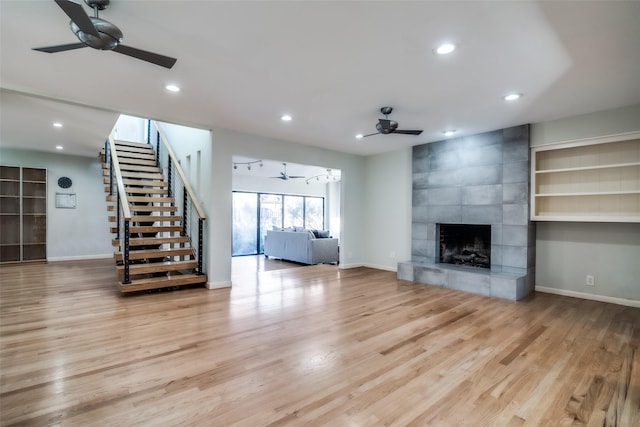 unfurnished living room with a fireplace, light hardwood / wood-style floors, and ceiling fan