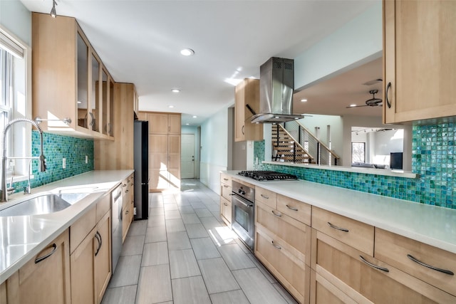 kitchen featuring sink, island range hood, light brown cabinets, stainless steel appliances, and decorative backsplash