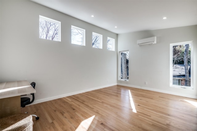 interior space with a wall unit AC and light wood-type flooring