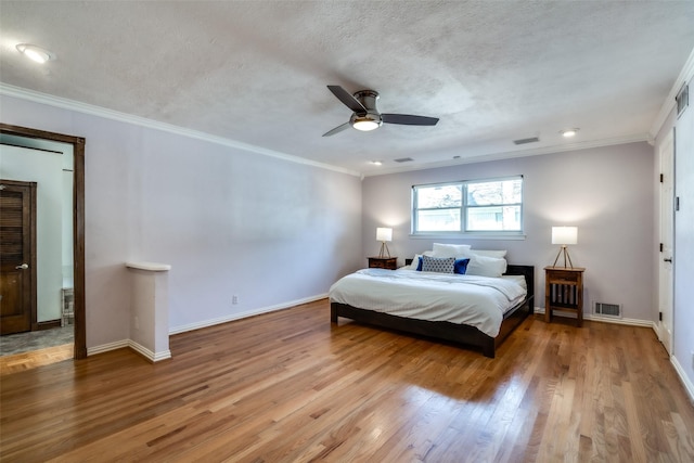 bedroom featuring ornamental molding, wood-type flooring, a textured ceiling, and ceiling fan