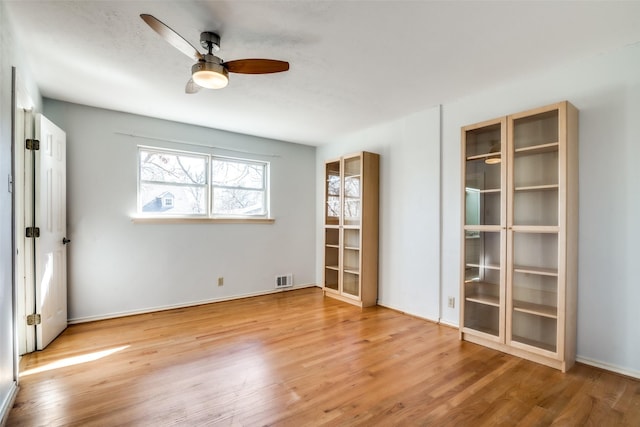 spare room with ceiling fan and wood-type flooring