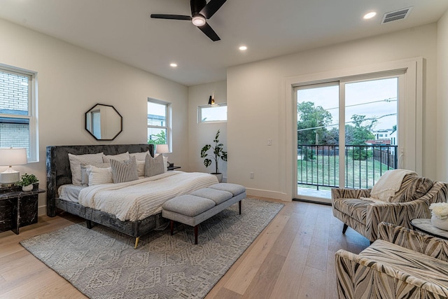 bedroom with access to exterior, ceiling fan, light hardwood / wood-style flooring, and multiple windows