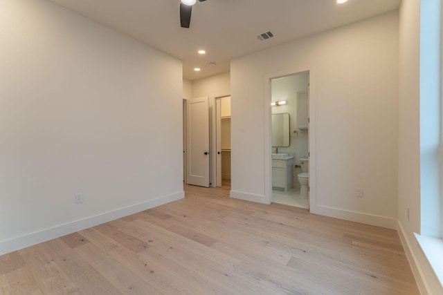 unfurnished bedroom with ceiling fan, light wood-type flooring, and connected bathroom