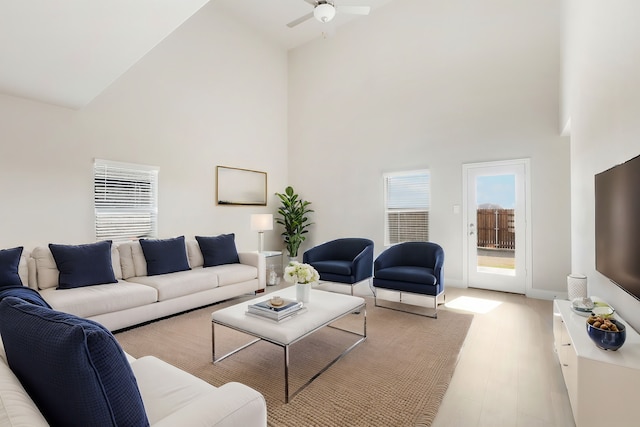 living room with high vaulted ceiling, ceiling fan, and light wood-type flooring