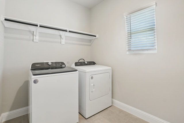 washroom with light tile patterned floors and washing machine and dryer