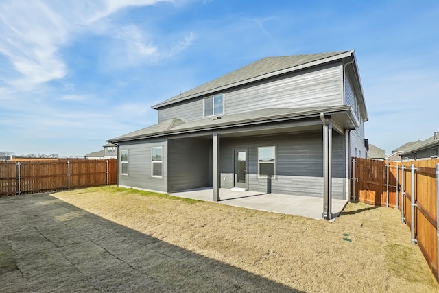 back of house with a lawn and a patio area