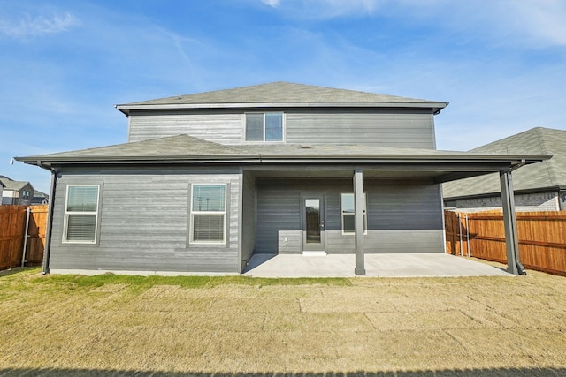 rear view of house with a lawn and a patio