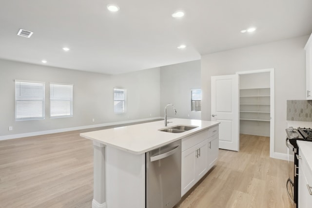 kitchen featuring range with gas cooktop, white cabinets, dishwasher, sink, and a center island with sink