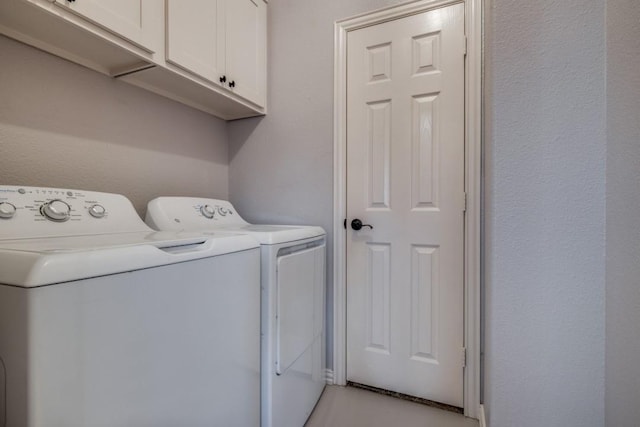 laundry room with washing machine and dryer and cabinets