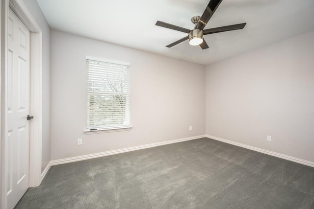 unfurnished room featuring ceiling fan and dark carpet