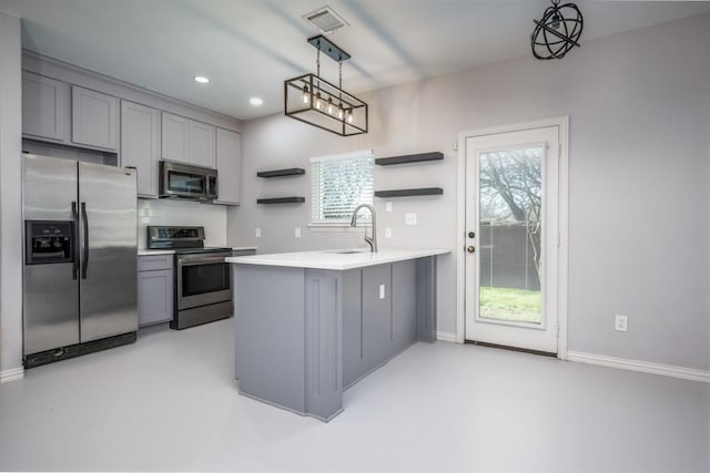 kitchen featuring sink, stainless steel appliances, kitchen peninsula, decorative light fixtures, and gray cabinets