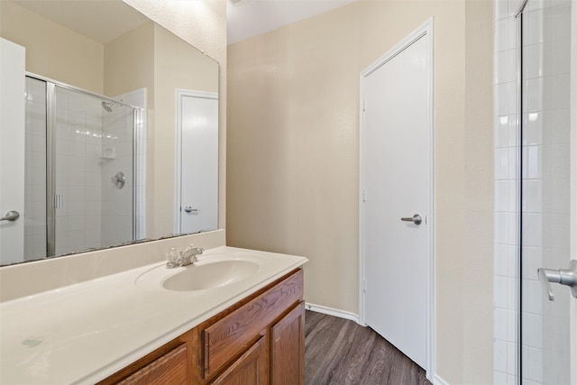 bathroom featuring vanity, hardwood / wood-style floors, and a shower with shower door