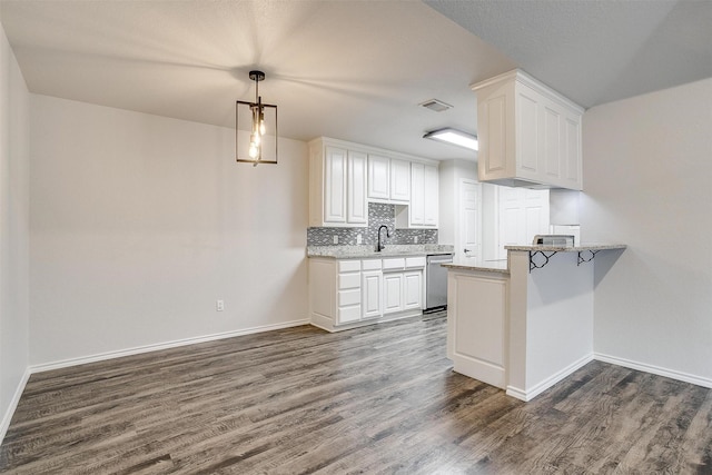 kitchen featuring white cabinetry, dishwasher, sink, tasteful backsplash, and kitchen peninsula