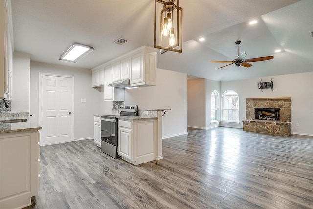 kitchen featuring ceiling fan, a fireplace, light hardwood / wood-style floors, white cabinetry, and stainless steel electric range