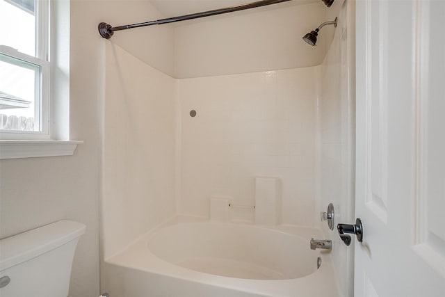 bathroom with bathing tub / shower combination and toilet