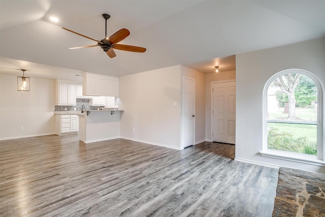 unfurnished living room featuring ceiling fan, light wood-type flooring, and sink