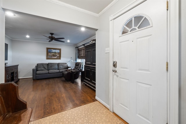 foyer with ceiling fan, wood-type flooring, and ornamental molding