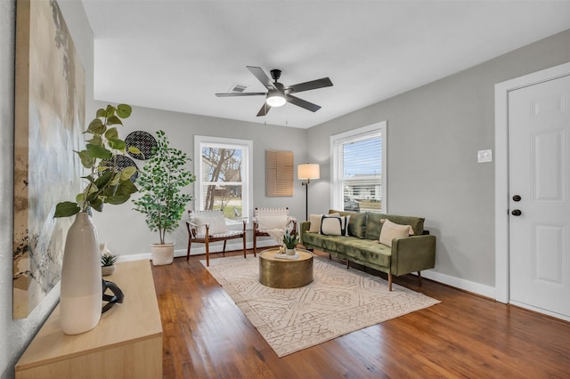 living room featuring ceiling fan and dark hardwood / wood-style flooring