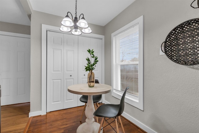 dining area with dark hardwood / wood-style floors and a notable chandelier