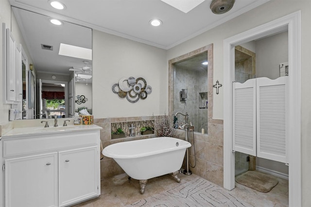 bathroom with vanity, crown molding, a skylight, tile walls, and independent shower and bath