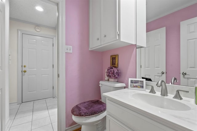 bathroom featuring tile patterned flooring, vanity, toilet, and crown molding