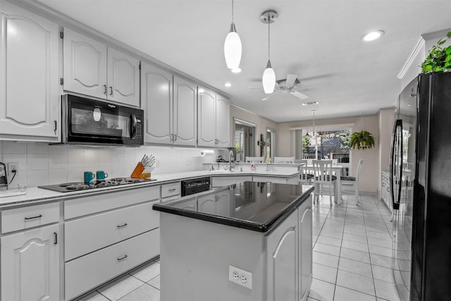 kitchen with pendant lighting, a center island, black appliances, ceiling fan, and kitchen peninsula