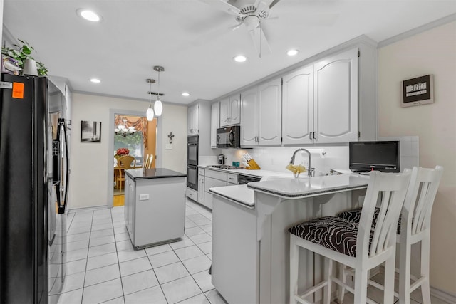 kitchen featuring a center island, sink, hanging light fixtures, kitchen peninsula, and stainless steel appliances