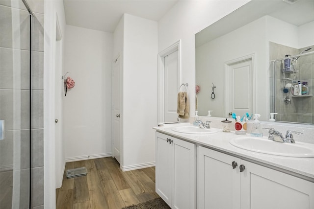 bathroom with hardwood / wood-style flooring, vanity, and an enclosed shower