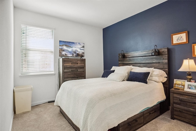 bedroom with light colored carpet and multiple windows