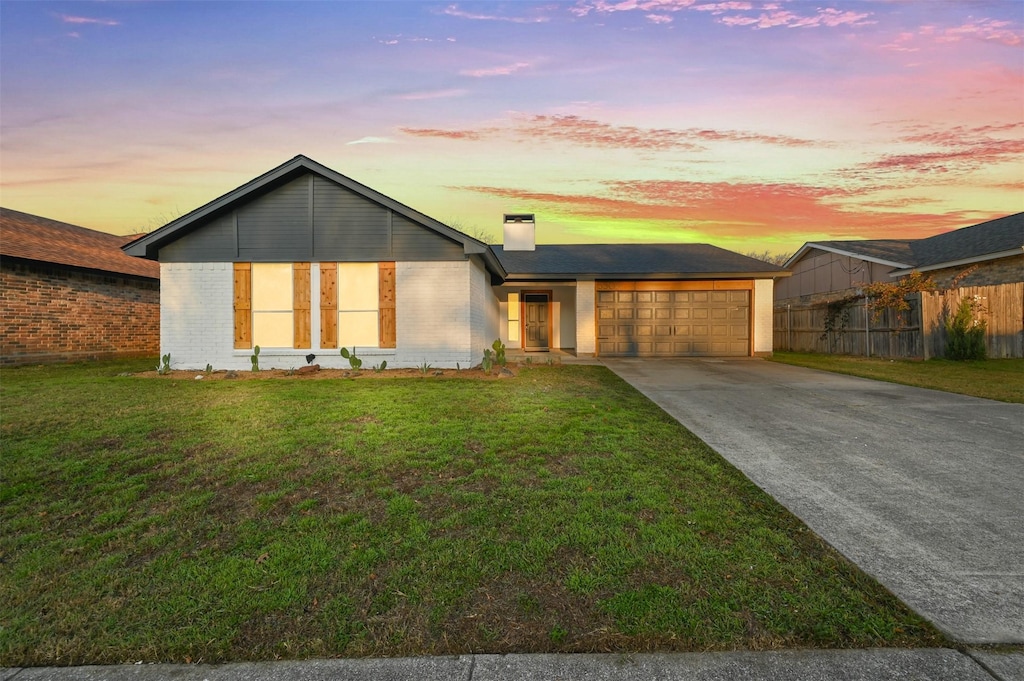 view of front of home featuring a garage and a lawn