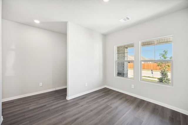 empty room featuring recessed lighting, dark wood finished floors, visible vents, and baseboards