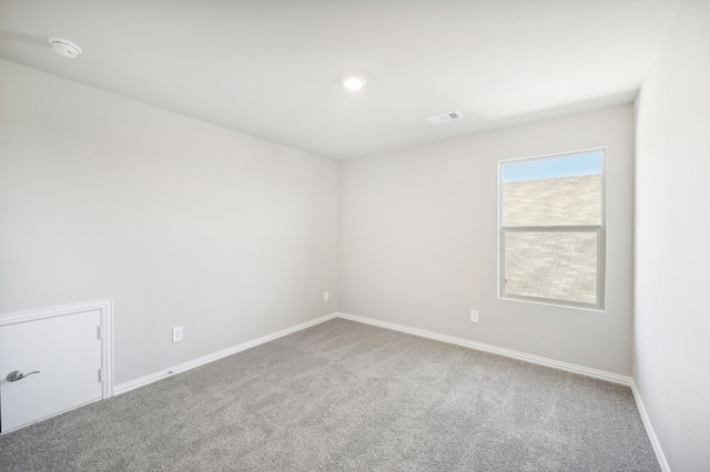 unfurnished room with baseboards, visible vents, and carpet flooring