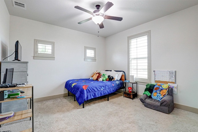 carpeted bedroom featuring ceiling fan and multiple windows