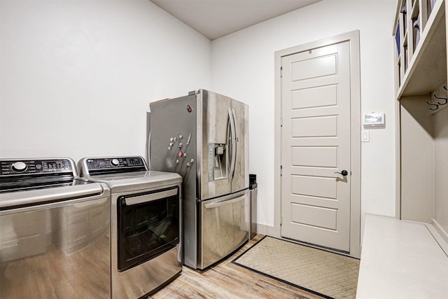 laundry room featuring light hardwood / wood-style floors and washer and clothes dryer