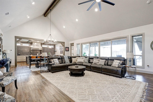 living room featuring beam ceiling, high vaulted ceiling, wood-type flooring, and ceiling fan with notable chandelier