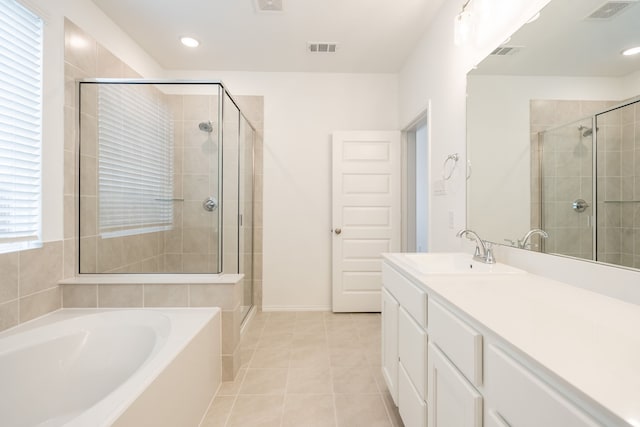 bathroom featuring independent shower and bath, vanity, and tile patterned floors