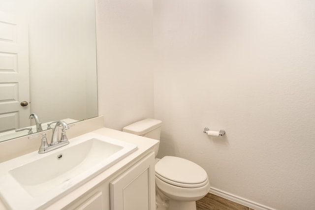 bathroom featuring vanity, toilet, and hardwood / wood-style floors