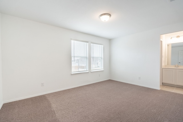 spare room featuring light carpet and sink