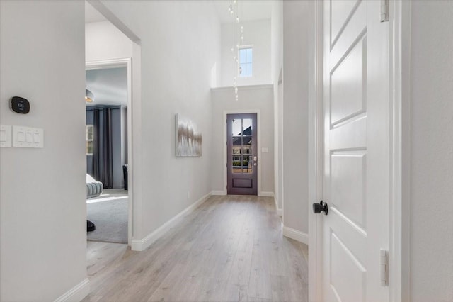 foyer entrance featuring a high ceiling and light wood-type flooring