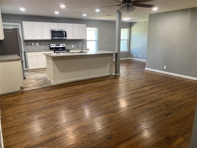 kitchen featuring sink, a center island with sink, appliances with stainless steel finishes, dark hardwood / wood-style floors, and white cabinets