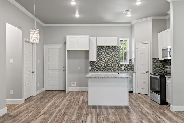 kitchen featuring white cabinetry, hanging light fixtures, light stone counters, appliances with stainless steel finishes, and ornamental molding