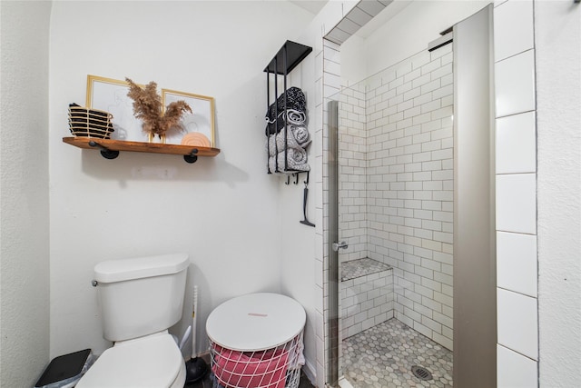 bathroom featuring toilet and tiled shower