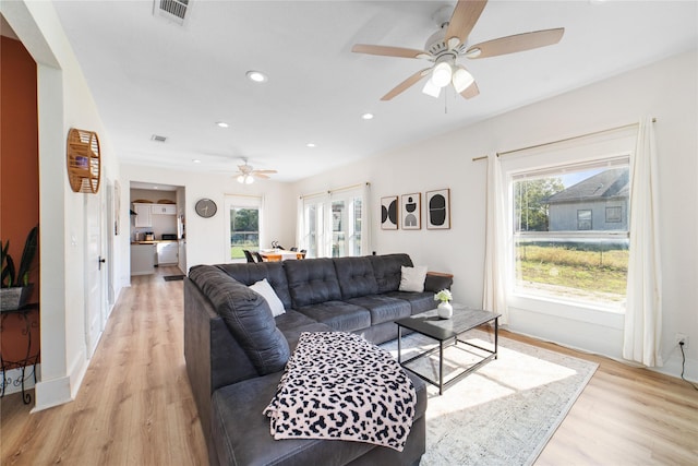 living room with ceiling fan, light hardwood / wood-style floors, and a wealth of natural light