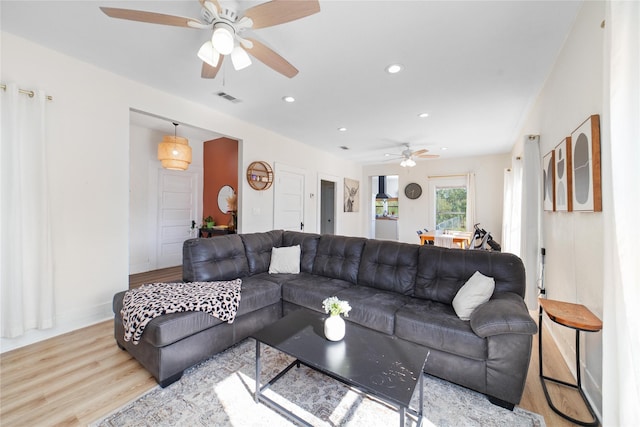 living room with ceiling fan and light hardwood / wood-style flooring